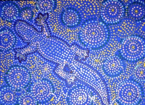Encaustic art in the style of aborigine painting composed of many dots.  The vivid image, composed of blue, yellow and white dots, is of the outline of a lizard against a background of round flowers. 
